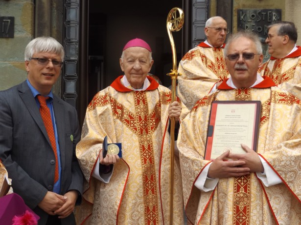 Erzbischof em. Edmund Piszcz freut sich über die Andreasplakette, die ihm Norbert Block (Vorsitzender des Ermlandfamilie e.V., l.) und Msgr. Achim Brennecke (Ermländische Priesterbruderschaft St. Andreas) überreichten. Foto: Bombeck